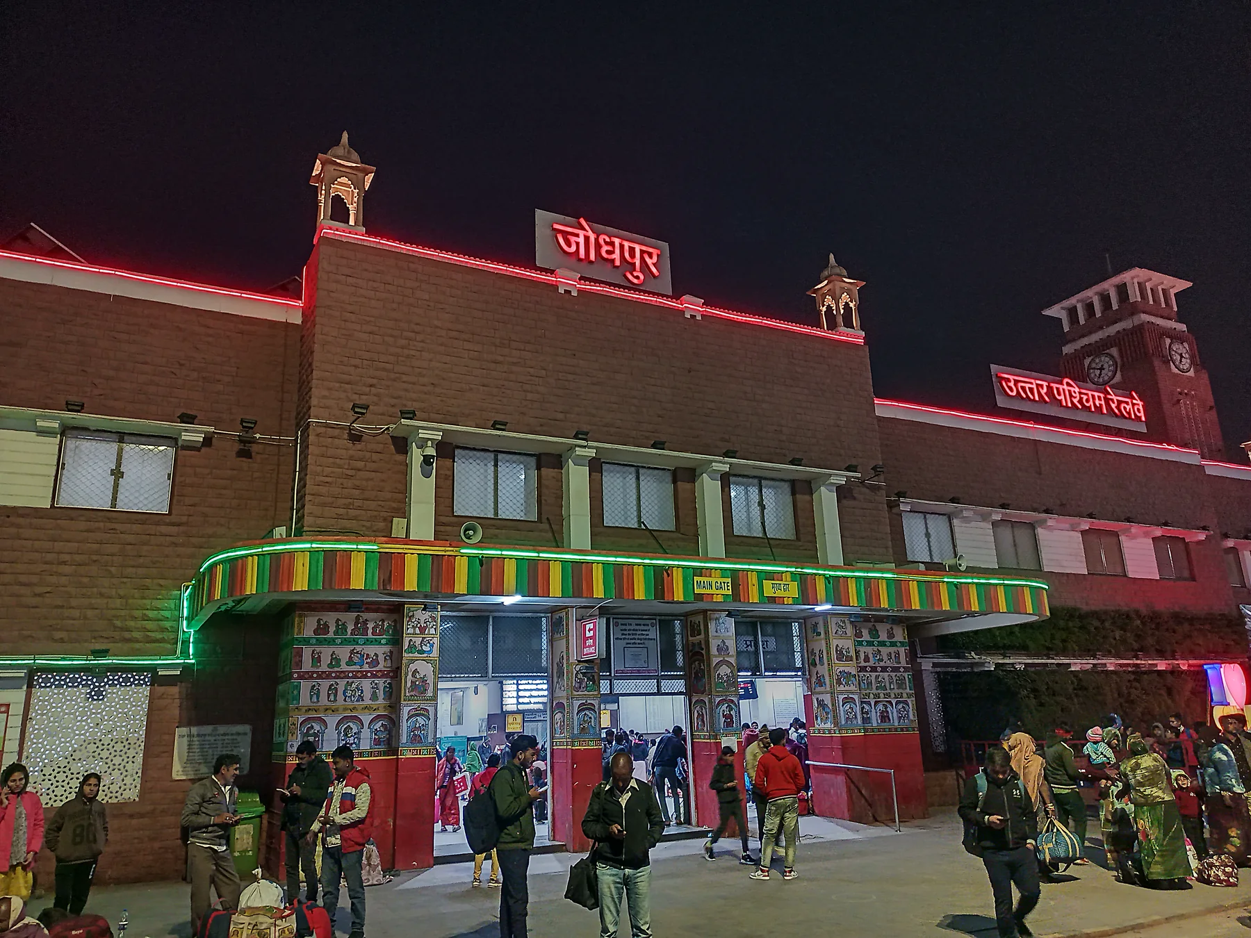 Illuminated entrance to Jodhpur railway station with travellers in 2023